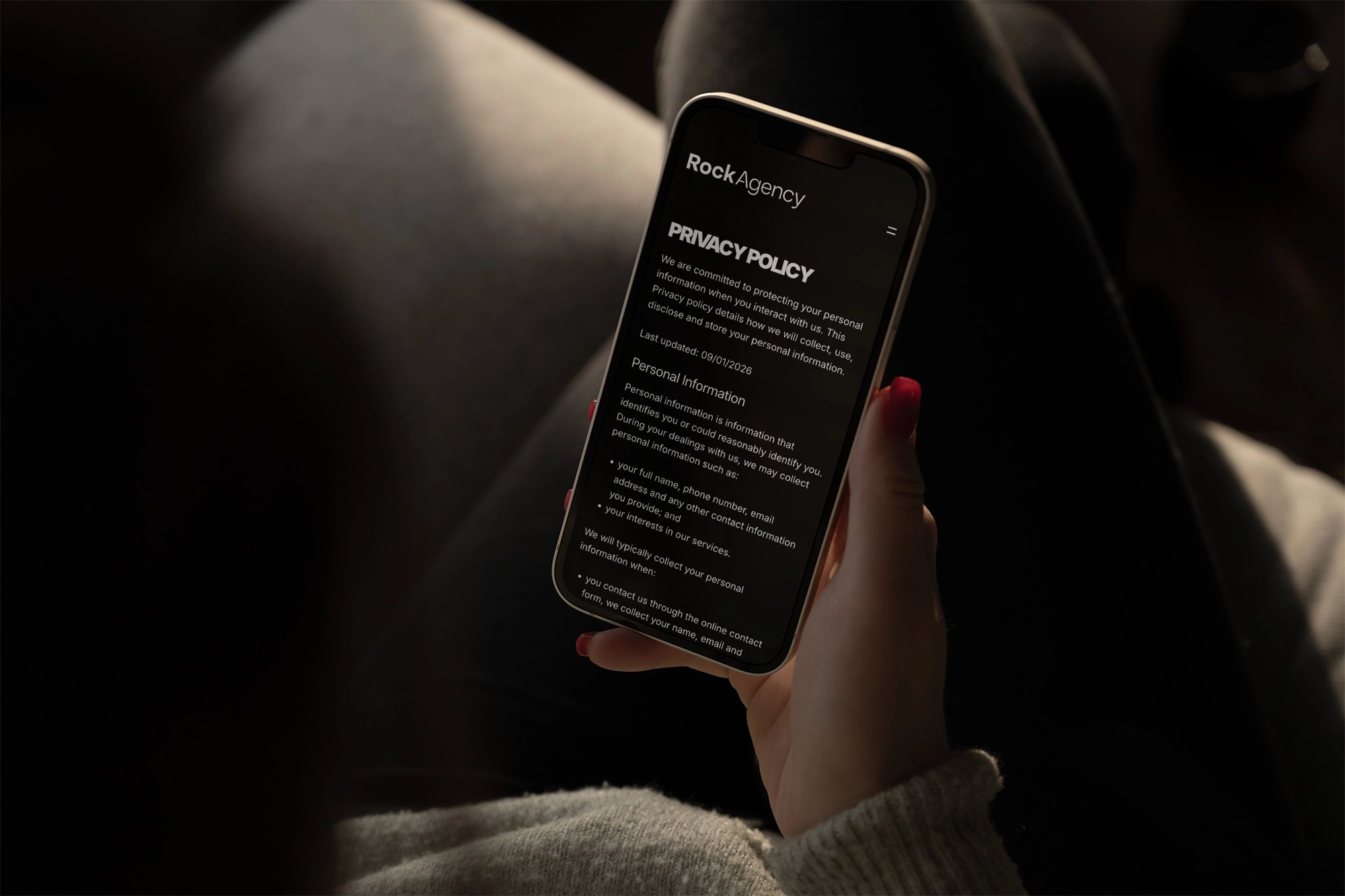 person holding phone that shows Rock Agency's privacy policy